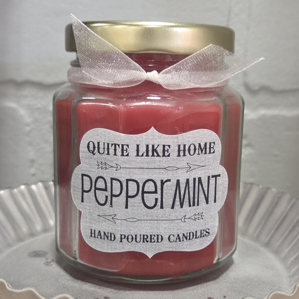 Peppermint scented 6.5 oz. jar candle with gold lid and organza ribbon.