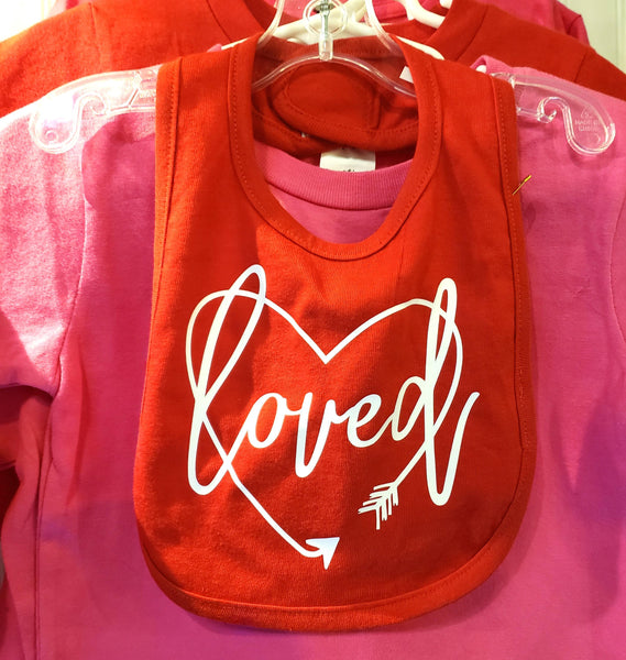 Loved surrounded by a heart shaped arrow bib.