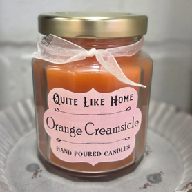 Orange Creamsicle scented 6.5 oz. jar candle with gold lid, & organza ribbon.