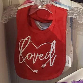 Loved surrounded by a heart shaped arrow bib.